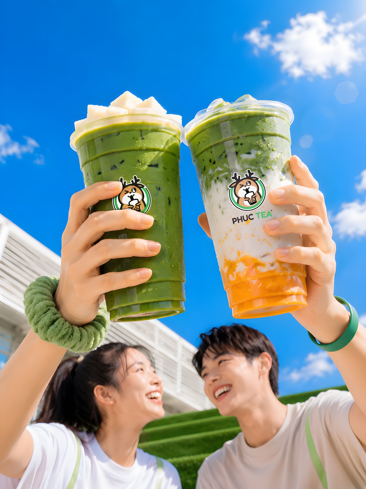 Hai bạn trẻ nâng ly matcha Phúc Tea dưới trời xanh